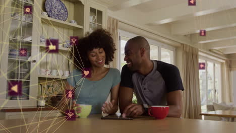 animation of network of connections with icons over african american couple drinking coffee