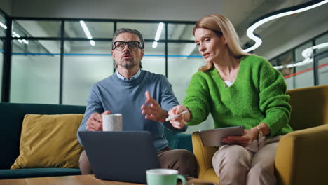 Smiling-businesspeople-collaborating-couch-close-up.-Businessman-gesturing-hands