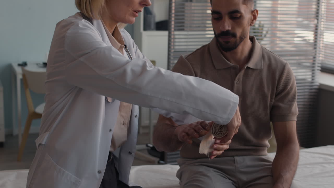 Doctor bandaging patient's hand