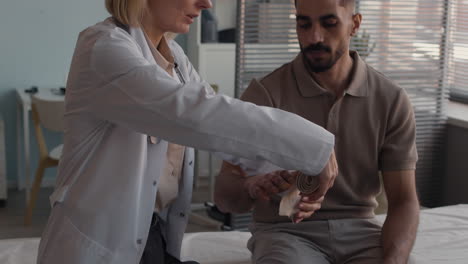 doctor bandaging patient's hand