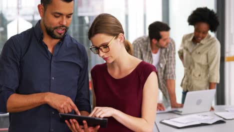 business executives discussing over digital tablet