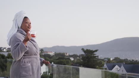 african american plus size woman drinking tea on balcony, unaltered, copy space, slow motion
