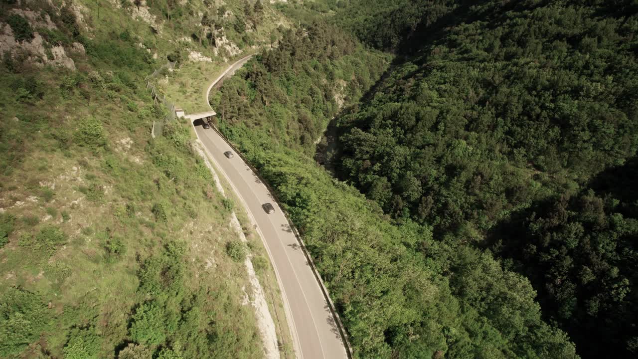 Aerial forward view of street inside a wild mountain with cars. Lavello. Italy