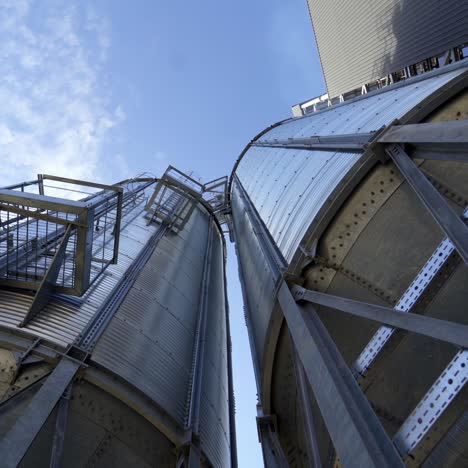 metal storage tanks. large grain elevators against blue sky. modern warehouse. close-up. view from below.
