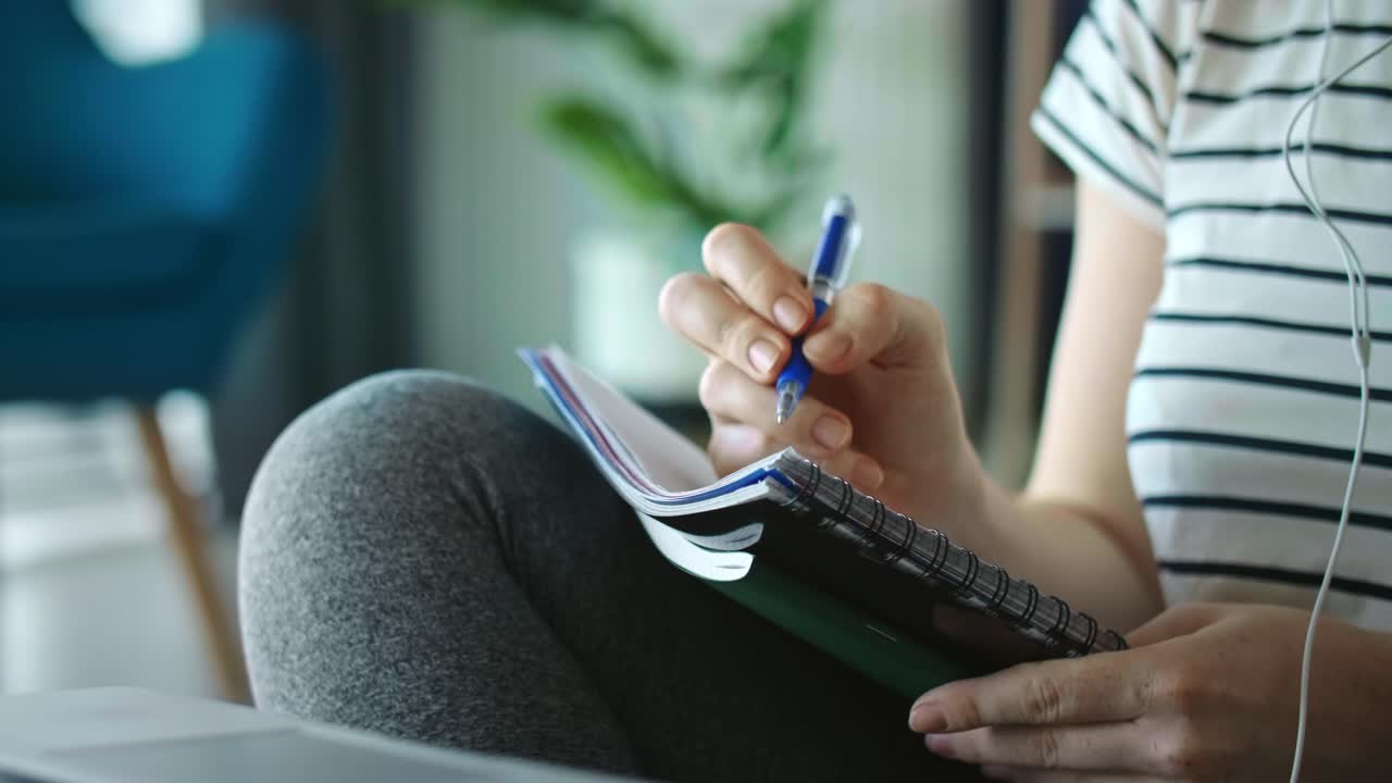 Handheld video of unrecognizable woman during e-learning at home
