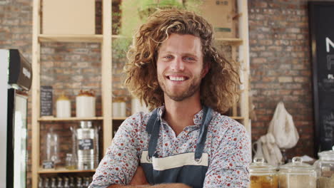 Portrait-Of-Male-Owner-Of-Sustainable-Plastic-Free-Grocery-Store-Behind-Sales-Desk