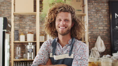 portrait of male owner of sustainable plastic free grocery store behind sales desk