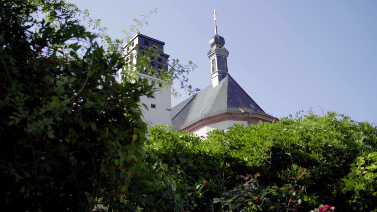 A Church with a Tall Tower Seen Through Lush Greenery