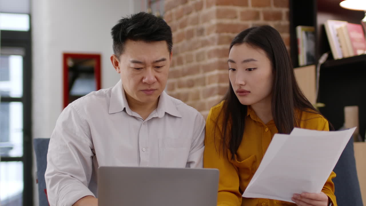 Couple Reviewing Documents at Home
