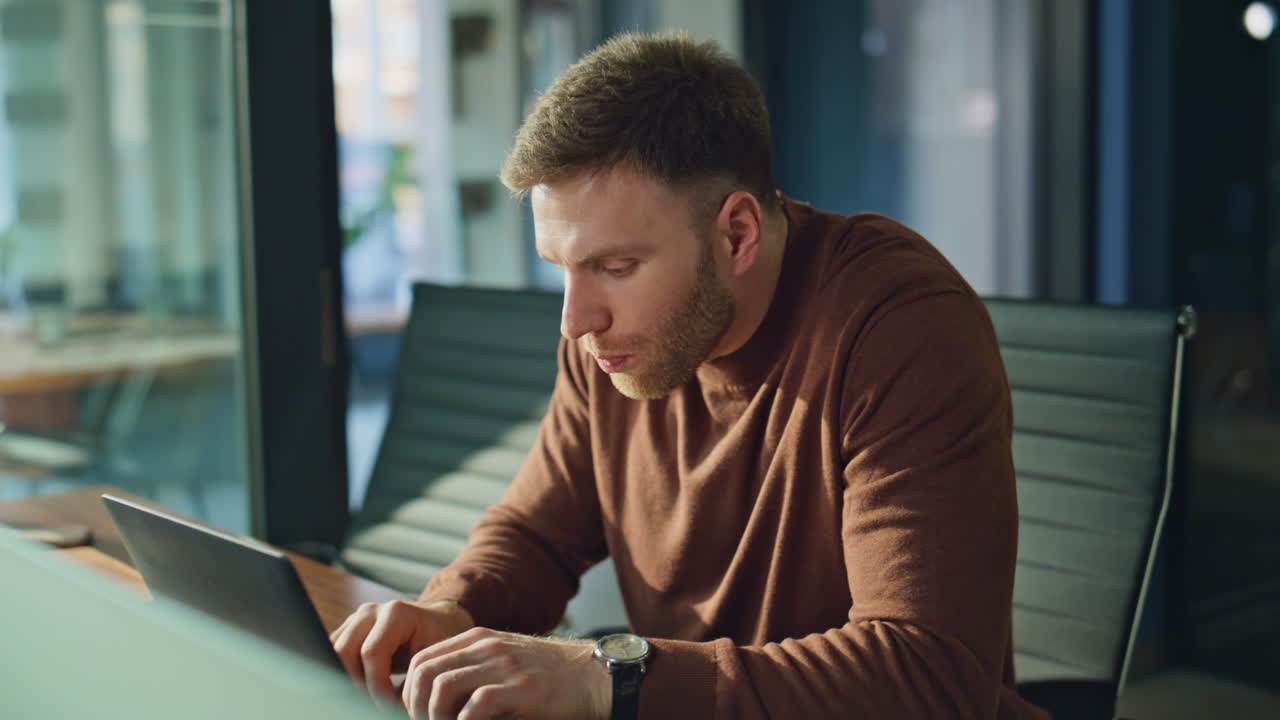 Pensive businessman drinking coffee at desk office pondering project closeup