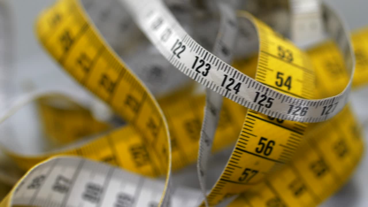 primer plano de la rotación de cintas métricas americanas y europeas, pulgadas y centímetros, métrica vs.