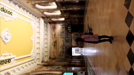 solitary woman in sao bento train station at night, porto