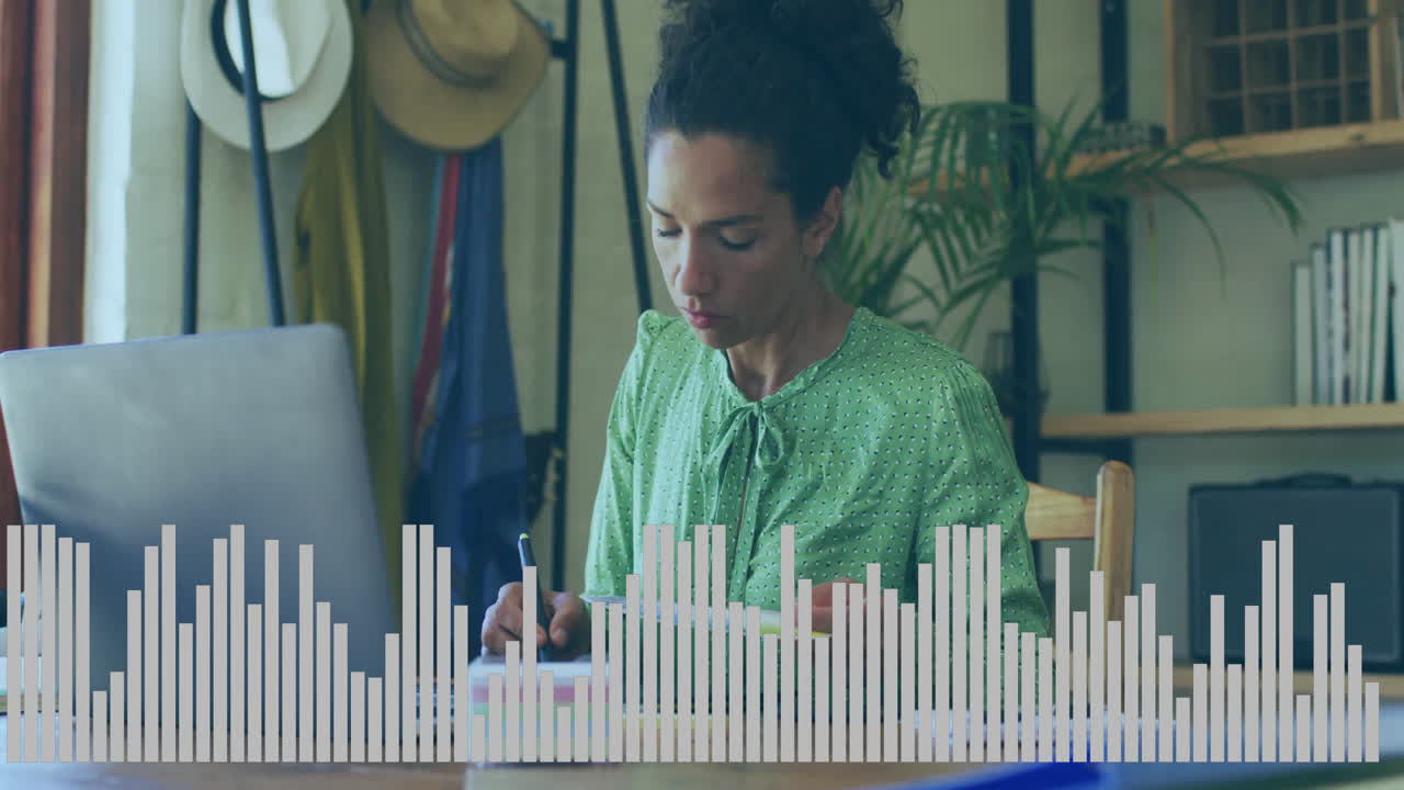 Business freelancer woman writing notes at home desk, using laptop with animated bar chart overlay
