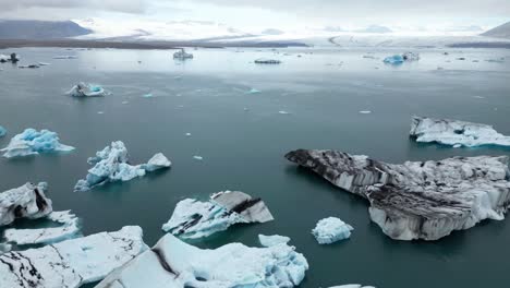 Vista-Aérea-Desde-La-Laguna-Glaciar-Jokulsarlon-En-Islandia-Durante-El-Tiempo-Con-Icebergs-Que-Fluyen-Libremente-Compuestos-De-Hielo-Que-Tiene-Más-De-1000-Años
