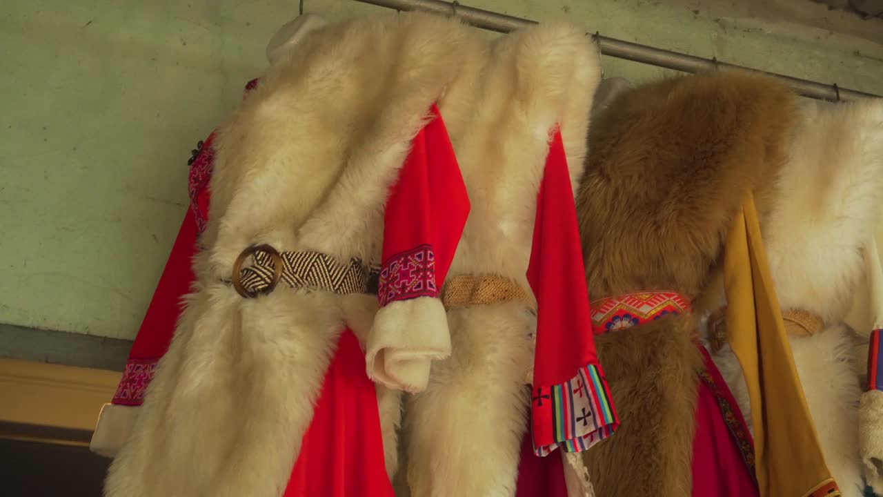 Traditional fur garments adorned with colorful woven patterns, hanging in a rustic village near Sapa, North Vietnam. Ideal for concepts of heritage, culture, and craftsmanship.