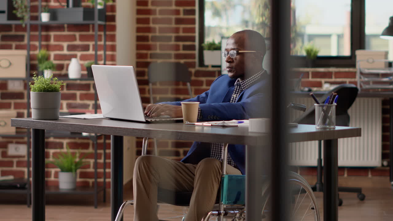 Project manager creating report on laptop in disability friendly office