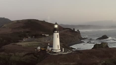 cinematic aerial orbit, yaquina head lighthouse, circling around over ocean