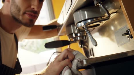 camarero masculino limpiando la cafetera 4k