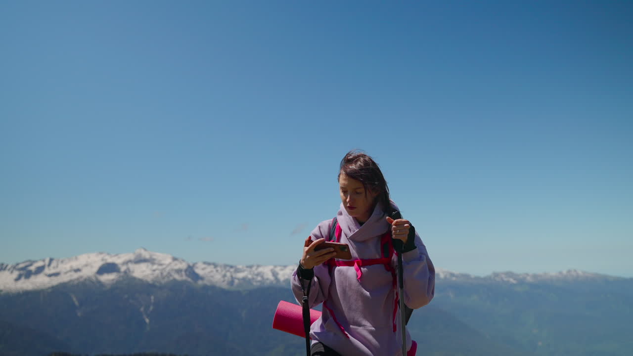 Donna in escursione in montagna con smartphone
