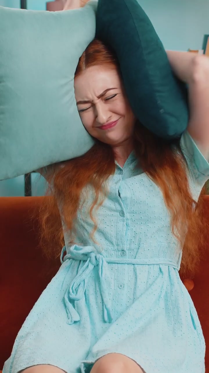 Lavoro di riparazione presso i vicini concetto donna irritata a casa copre le orecchie con cuscini infastidita dal rumore