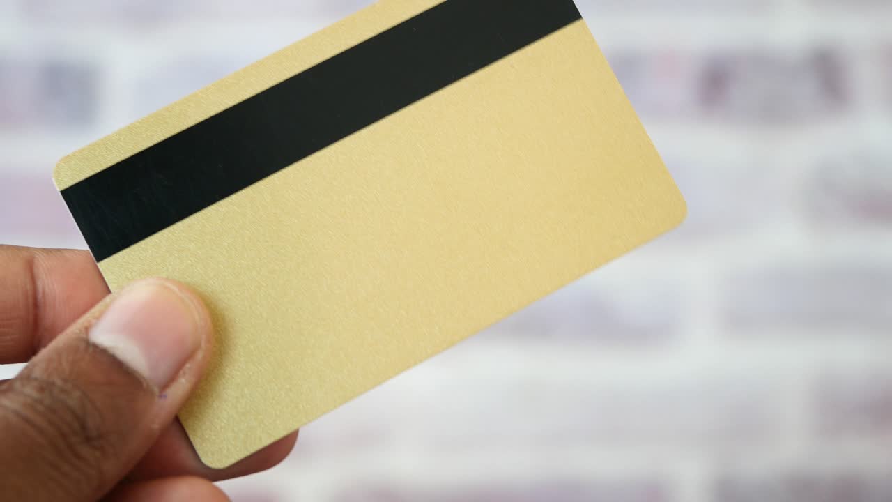 persona que escribe en una tarjeta de crédito de oro