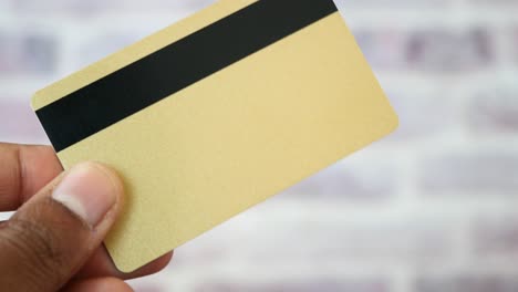 person writing on a gold credit card