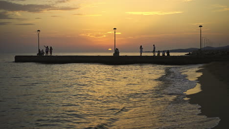 sunset at the beach with people on pier