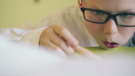 hungry boy in shirt eats tasty pizza at green plate closeup