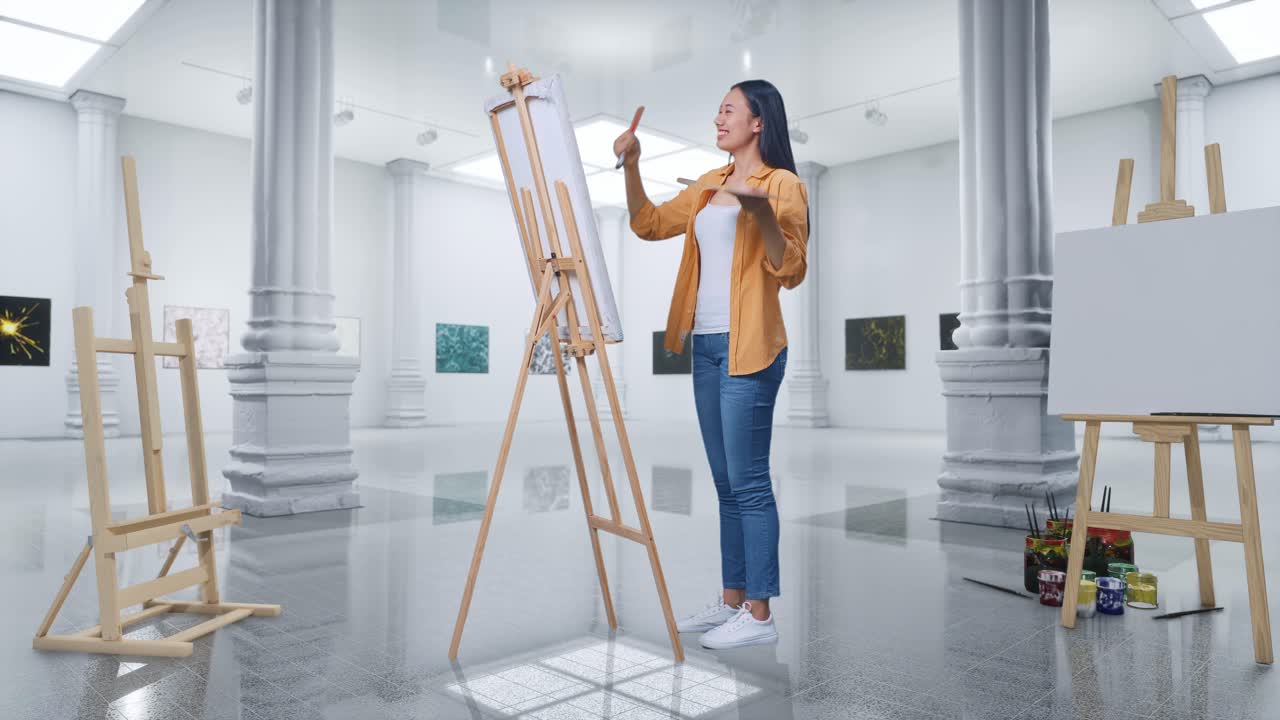 아시아 여성 예술가의 몸이 가득 차 있습니다. 갤러리에서 오일 페인트와 브러쉬로 캔버스에 마무리 된 그림을 축하하고 있습니다.