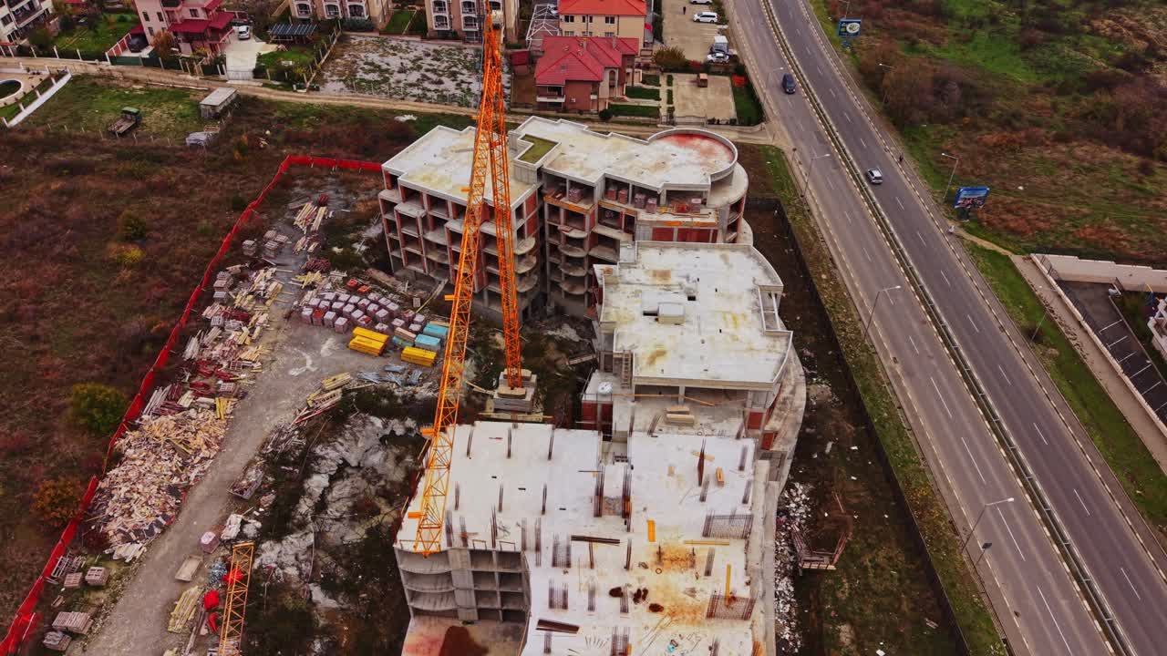 Construction site with a crane and nearby buildings in aerial view