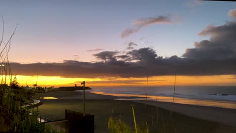 panorámica en cámara lenta desde el océano atlántico hasta la costa de la playa de carcavelos, colores y tonos del atardecer portugal