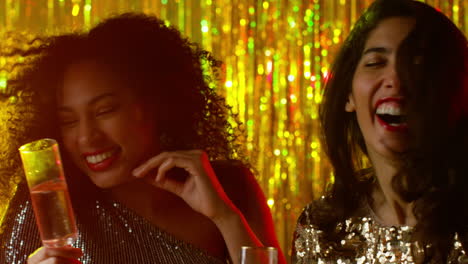 Close-Up-Of-Two-Women-Dancing-In-Nightclub-Bar-Or-Disco-Drinking-Alcohol-With-Sparkling-Lights-20