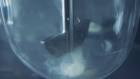 the procedures for corona virus testing are initiated in the laboratory. first mixes are prepared in a closed glass box.water vortex formed in beaker. magnetic mixing machine.