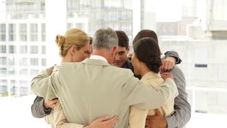 business people hugging each other in a circle