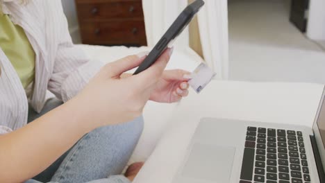 Caucasian-plus-size-woman-using-smartphone-and-holding-credit-card-in-slow-motion