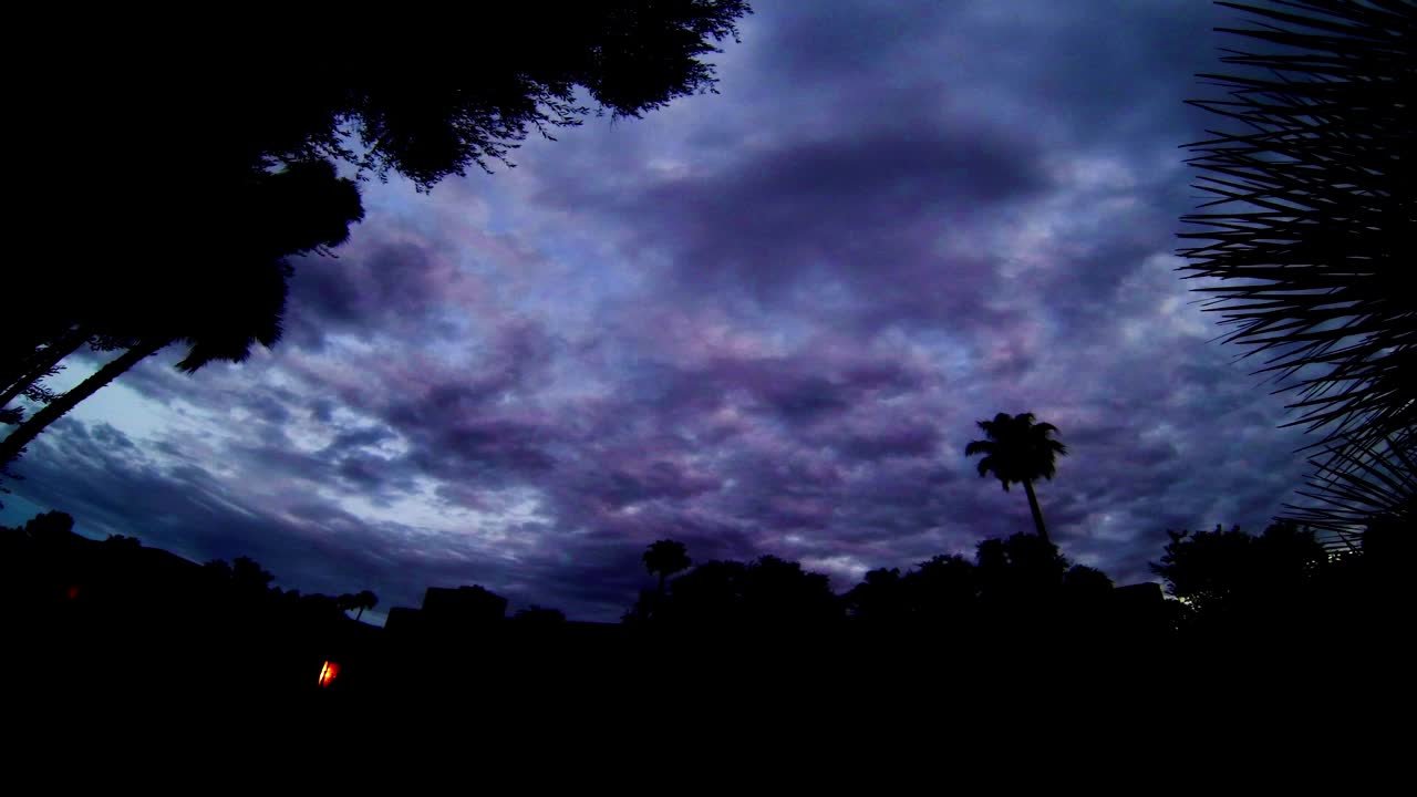 폭풍우 구름이 하늘 구름을 채우는 시간 경과 구름이 노란색과 주황색에서 진한 보라색으로 바뀝니다.