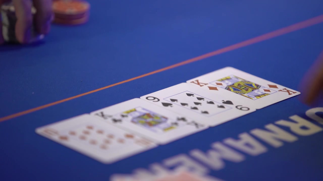 Filmato di casinò che mostra un croupier di poker che apre una carta comune durante una partita a poker. Concetto di gioco d'azzardo, scommesse, Texas Hold'em e intrattenimento da casinò.
