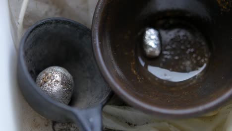 mercury and gold combined in a container forming a compound called amalgam - closeup shot