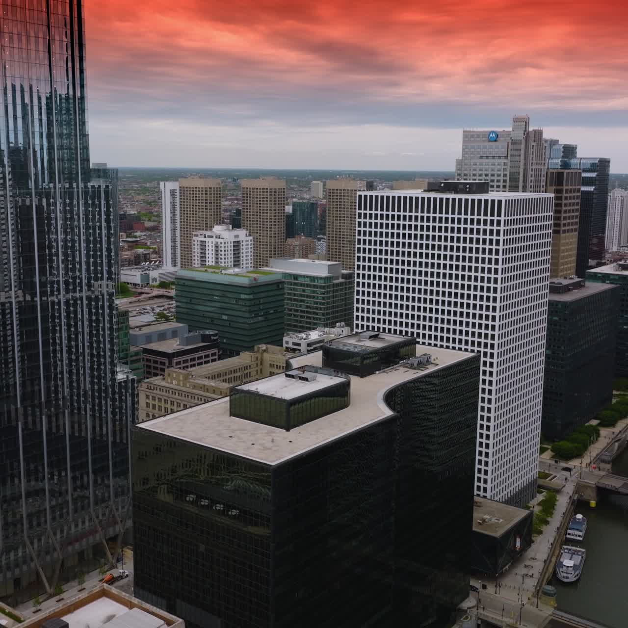 Contemporary buildings of modern Chicago. Drone flying over Chicago River among the beautiful architecture at the backdrop of pink sky