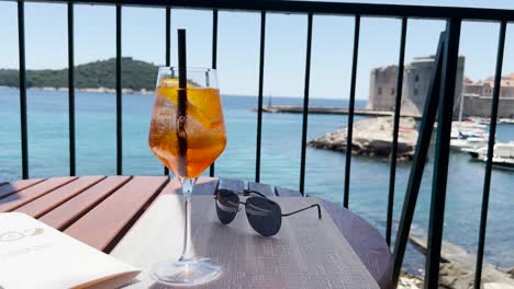 Wine-glass-of-cold-cocktail-Aperol-spritz-near-The-Old-Town-in-Dubrovnik,-Croatia