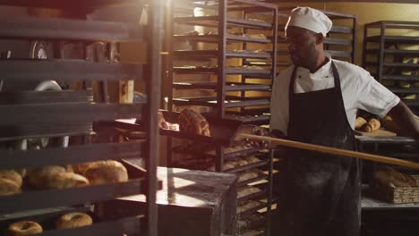 Animation-of-happy-african-american-male-baker-holding-wooden-spatula-with-challah