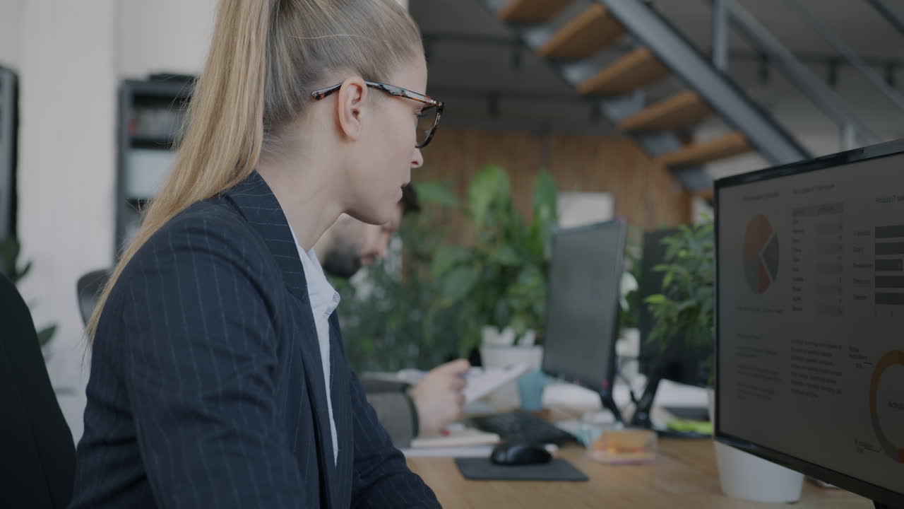 бизнесменка, работающая на компьютере в офисе