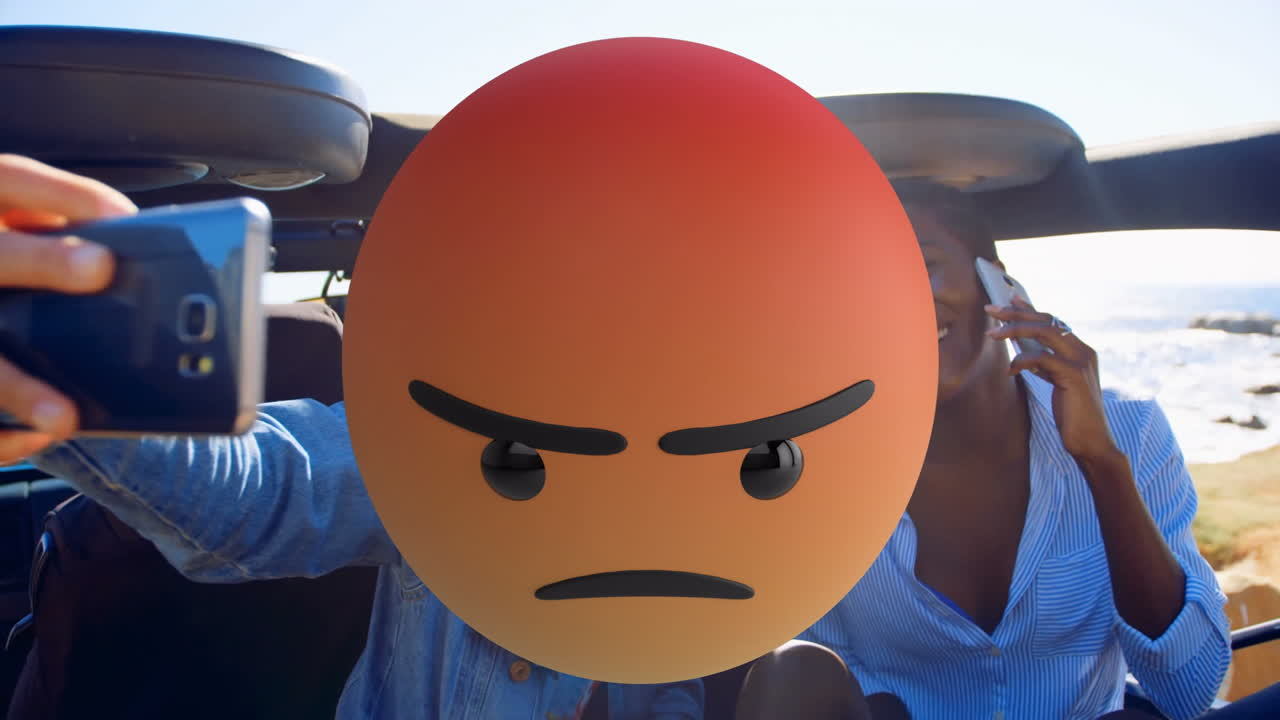 Angry emoji animation over people taking selfies in convertible car