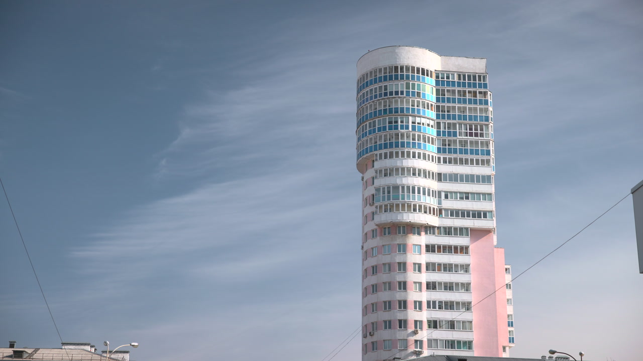 Modern Highrise Tower Against Blue Sky, Curved Glass Facade With Pastel Pink Base, Stacked Balconies . Media