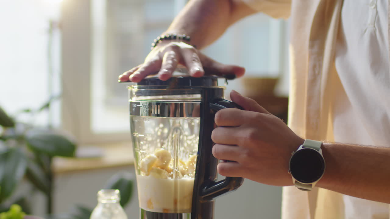 Man Pouring Plant Based Milk in Blender with Fruit