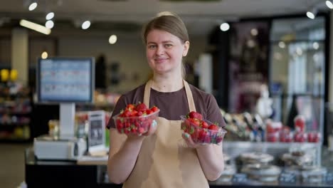 Porträt-Einer-Glücklichen-Supermarktangestellten,-Die-Zwei-Kisten-Mit-Roten-Erdbeeren-In-Den-Händen-Hält