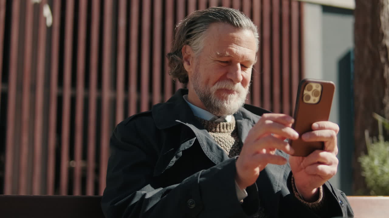 Smiling Senior Man Using Phone Outdoors