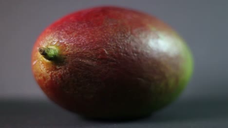 close-up of spinning mango fruit on a grey background