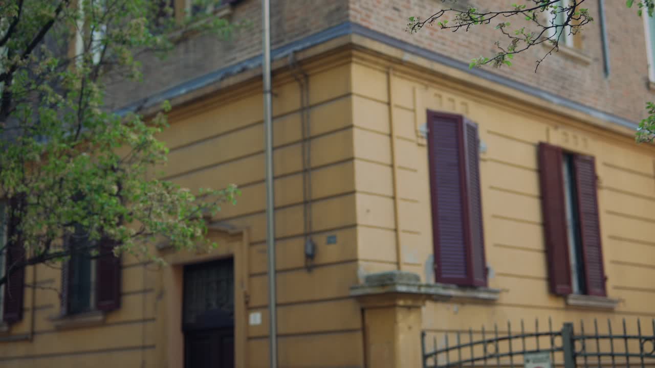 Italian building with trees and brown shutters
