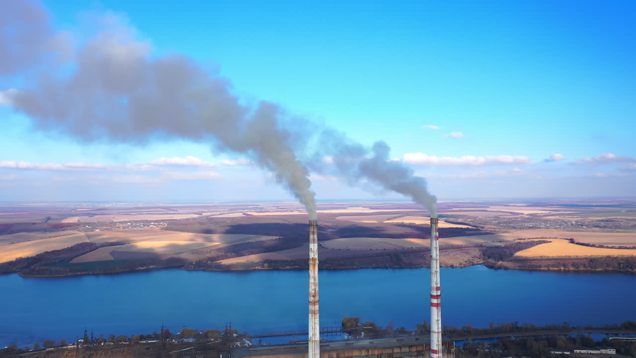 Aerial view of smoking factory tubes. Indusrty energy producing air pollution.